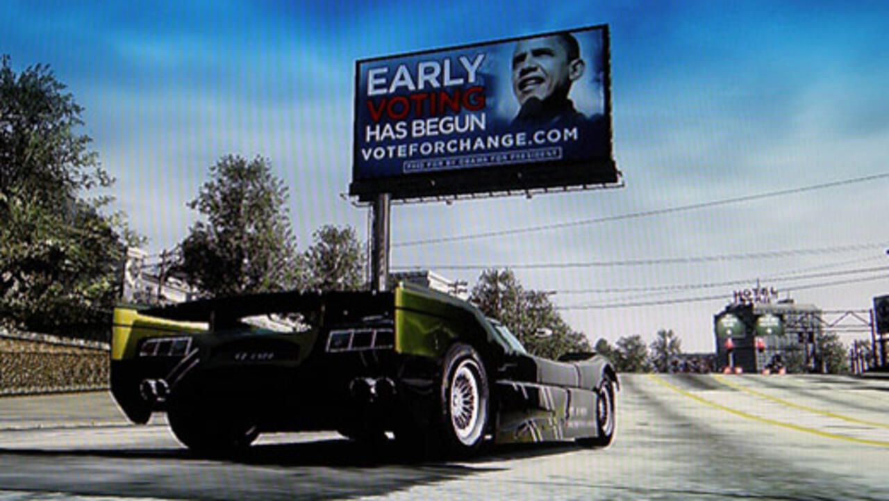 A racing game billboard reading “EARLY VOTING HAS BEGUN — VOTEFORCHANGE.COM” with Barack Obama’s photo, seen from behind a sports car